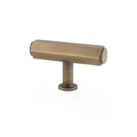 This is an image showing Alexander & Wilks - Vesper Hex T - Bar Cabinet Knob - Antique Brass aw829-55-ab available to order from T.H. Wiggans Ironmongery in Kendal, quick delivery and discounted prices.