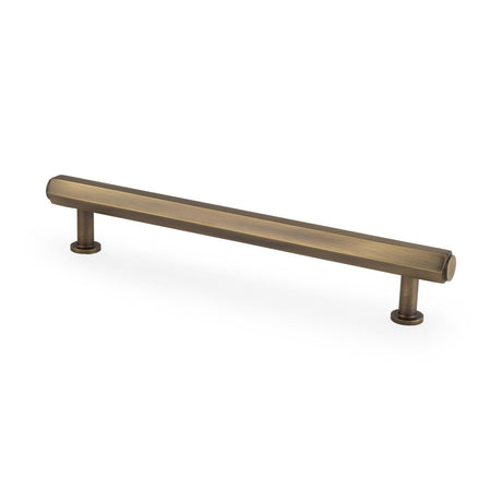 This is an image showing Alexander & Wilks - Vesper Hex T - Bar Cabinet Pull - Antique Brass - 160mm C/C aw830-160-ab available to order from T.H. Wiggans Ironmongery in Kendal, quick delivery and discounted prices.