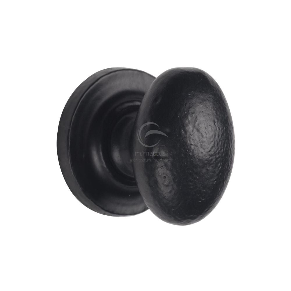 This is an image of a M.Marcus - Black Iron Rustic Cabinet Knob on Round Plate Oval Design 32mm, fb179-32 that is available to order from T.H Wiggans Ironmongery in Kendal.