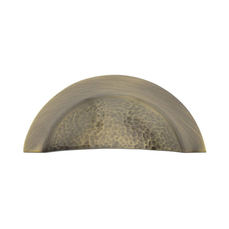 This is an image of a Heritage Brass - Drawer Cup Pull Crescent Hammered Design Antique Brass finish, ham1730-at that is available to order from T.H Wiggans Ironmongery in Kendal.