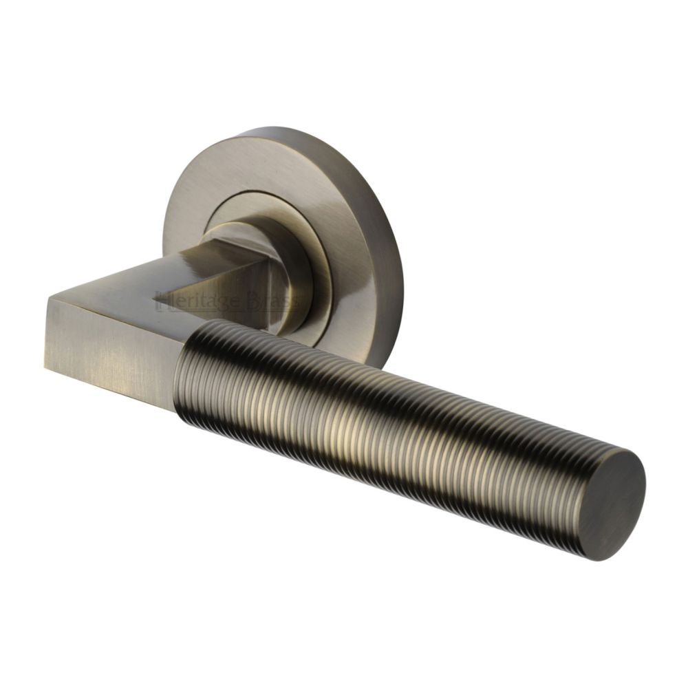 This is an image of a Heritage Brass - Door Handle Lever on Rose Spectral Design Antique Brass Finish, rs2261-at that is available to order from T.H Wiggans Ironmongery in Kendal.