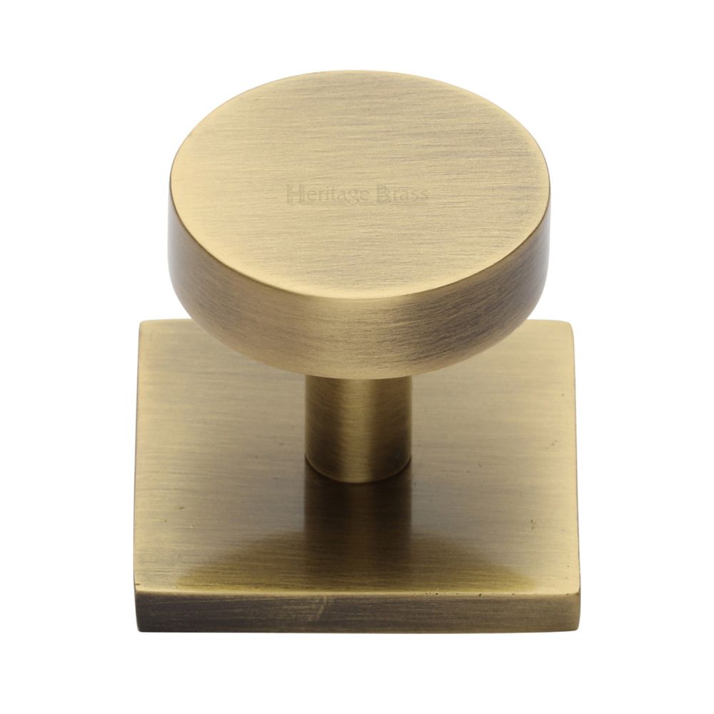 This is an image of a Heritage Brass - Cabinet Knob Disc Design with Square Backplate 32mm Antique Brass, sq3880-at that is available to order from T.H Wiggans Ironmongery in Kendal.