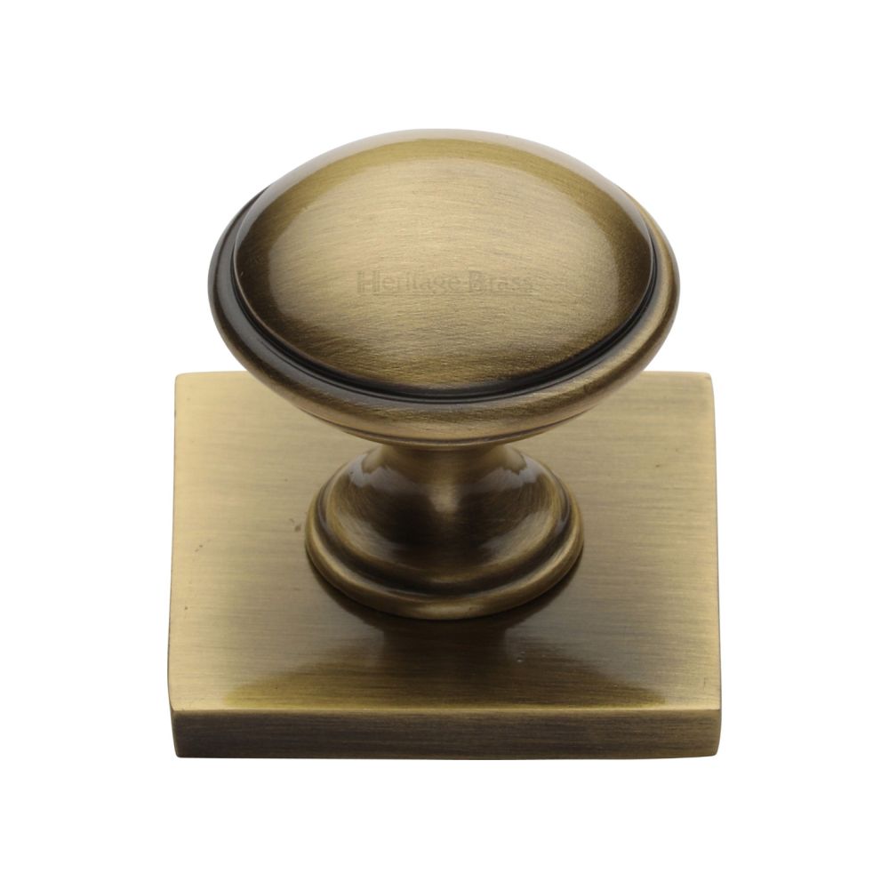 This is an image of a Heritage Brass - Cabinet Knob Domed Design with Square Backplate 32mm Antique Brass, sq3950-at that is available to order from T.H Wiggans Ironmongery in Kendal.