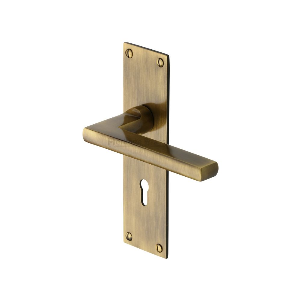 This is an image of a Heritage Brass - Door Handle Lever Lock Trident Design Antique Brass Finish, tri1300-at that is available to order from T.H Wiggans Ironmongery in Kendal.