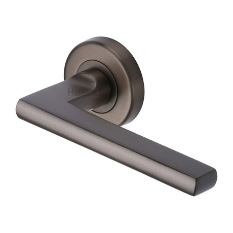 This is an image of a Heritage Brass - Door Handle Lever on Rose Trident Design Matt Bronze Finish, tri1352-mb that is available to order from T.H Wiggans Ironmongery in Kendal.