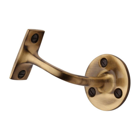This is an image of a Heritage Brass - Handrail Bracket 3" Antique Brass Finish, v1030-76-at that is available to order from T.H Wiggans Ironmongery in Kendal.