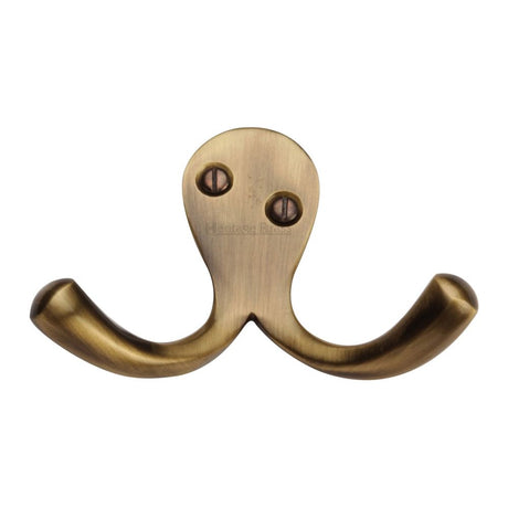 This is an image of a Heritage Brass - Double Coat Hook Antique Brass Finish, v1060-at that is available to order from T.H Wiggans Ironmongery in Kendal.