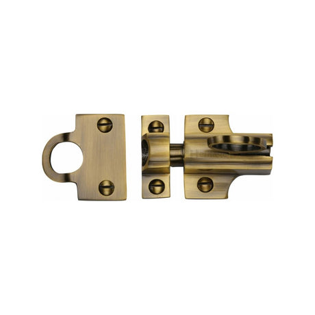 This is an image of a Heritage Brass - Fanlight Catch Antique Brass Finish, v1117-at that is available to order from T.H Wiggans Ironmongery in Kendal.