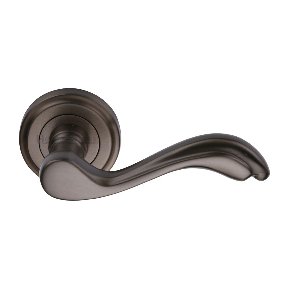 This is an image of a Heritage Brass - Door Handle Lever Latch on Round Rose Lisboa Design Matt Bronze, v1601-mb that is available to order from T.H Wiggans Ironmongery in Kendal.