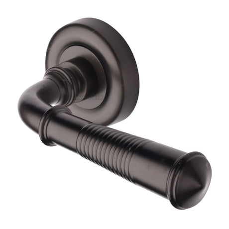 This is an image of a Heritage Brass - Door Handle Lever Latch on Round Rose Colonial Reeded Design Ma, v1936-mb that is available to order from T.H Wiggans Ironmongery in Kendal.