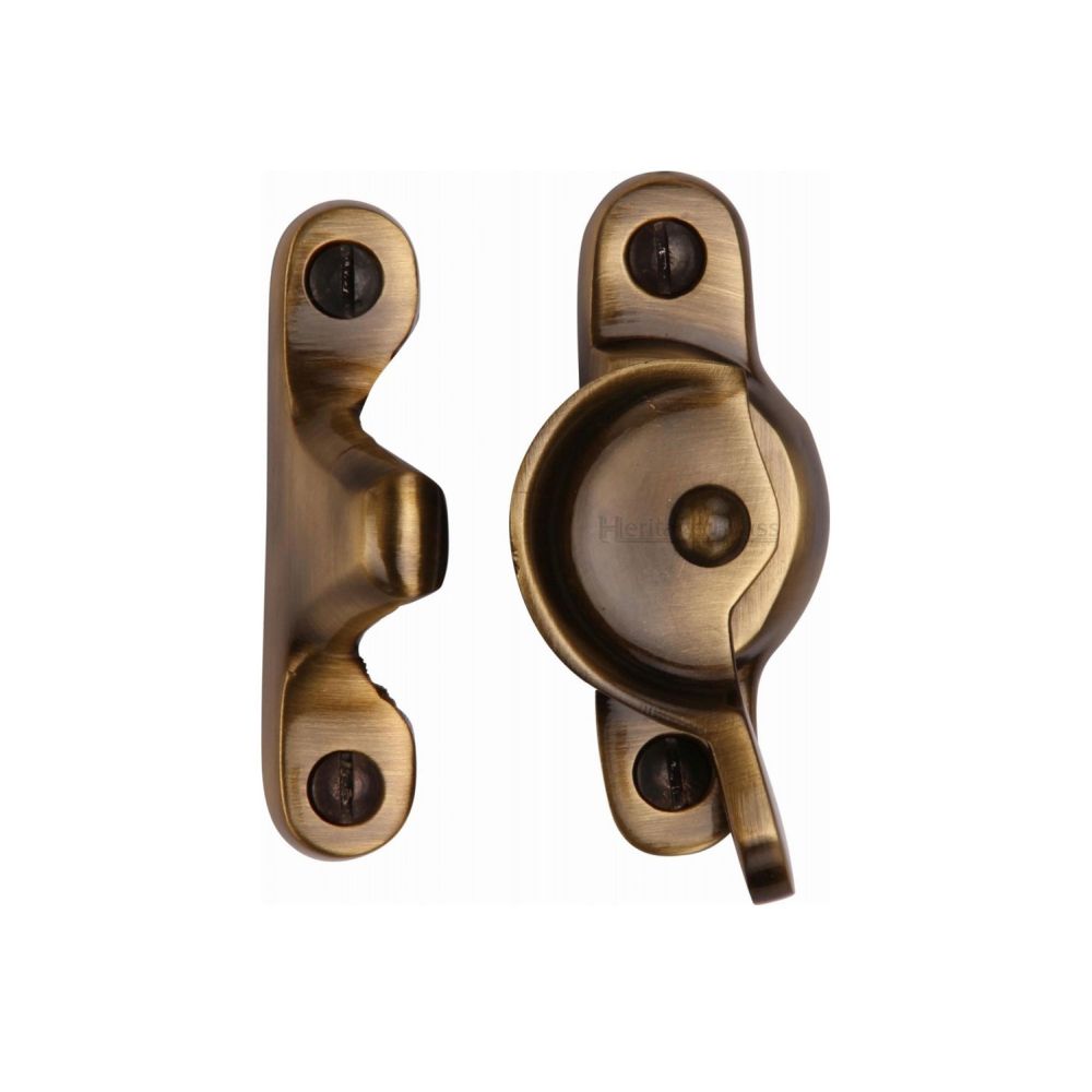 This is an image of a Heritage Brass - Fitch Pattern Sash Fastener Antique Brass Finish, v2060-at that is available to order from T.H Wiggans Ironmongery in Kendal.