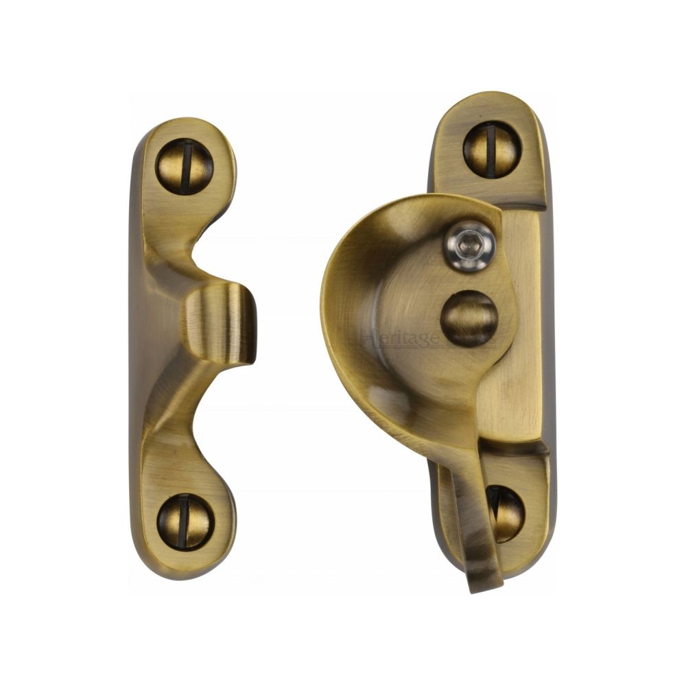 This is an image of a Heritage Brass - Fitch Pattern Sash Fastener Lockable Antique Brass Finish, v2060l-at that is available to order from T.H Wiggans Ironmongery in Kendal.