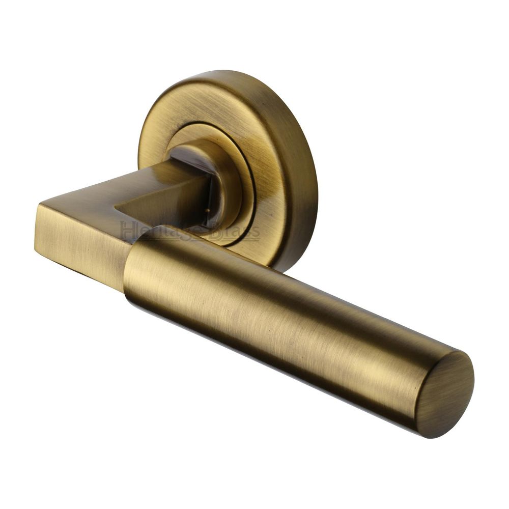 This is an image of a Heritage Brass - Door Handle Lever on Rose Bauhaus Design Antique Brass Finish, v2259-at that is available to order from T.H Wiggans Ironmongery in Kendal.