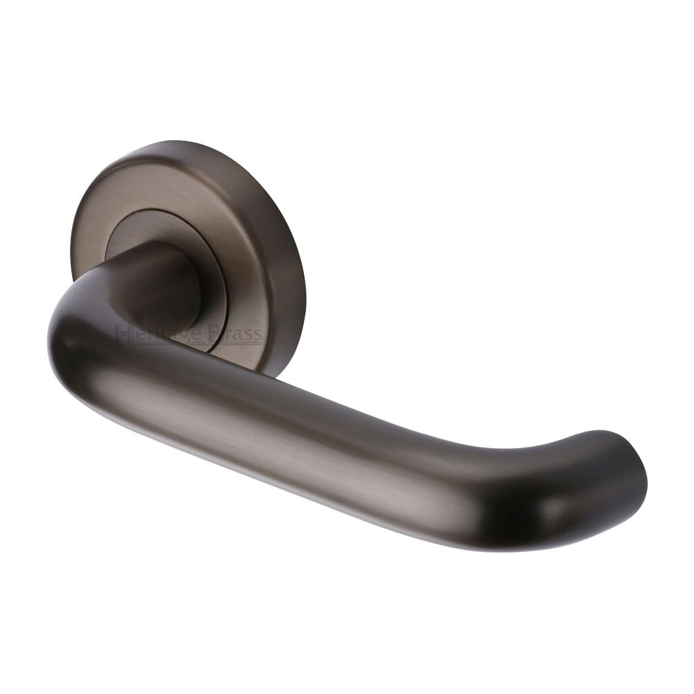This is an image of a Heritage Brass - Door Handle Lever Latch on Round Rose Harmony Design Matt Bronz, v3090-mb that is available to order from T.H Wiggans Ironmongery in Kendal.