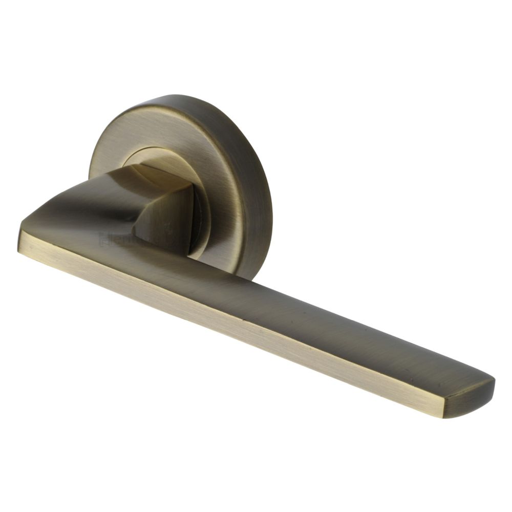 This is an image of a Heritage Brass - Door Handle Lever Latch on Round Rose Metro Angled Design Antique, v3790-at that is available to order from T.H Wiggans Ironmongery in Kendal.