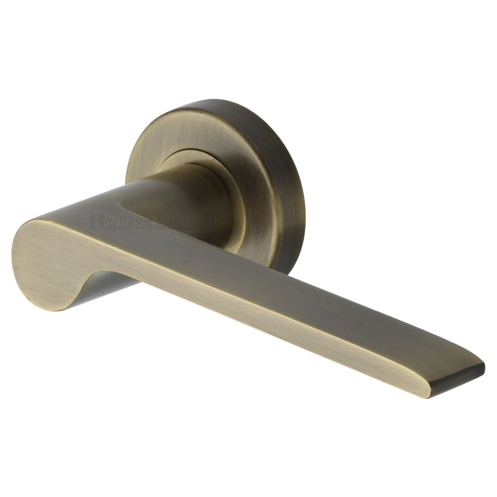 This is an image of a Heritage Brass - Door Handle Lever Latch on Round Rose Julia Design Antique Brass F, v4190-at that is available to order from T.H Wiggans Ironmongery in Kendal.