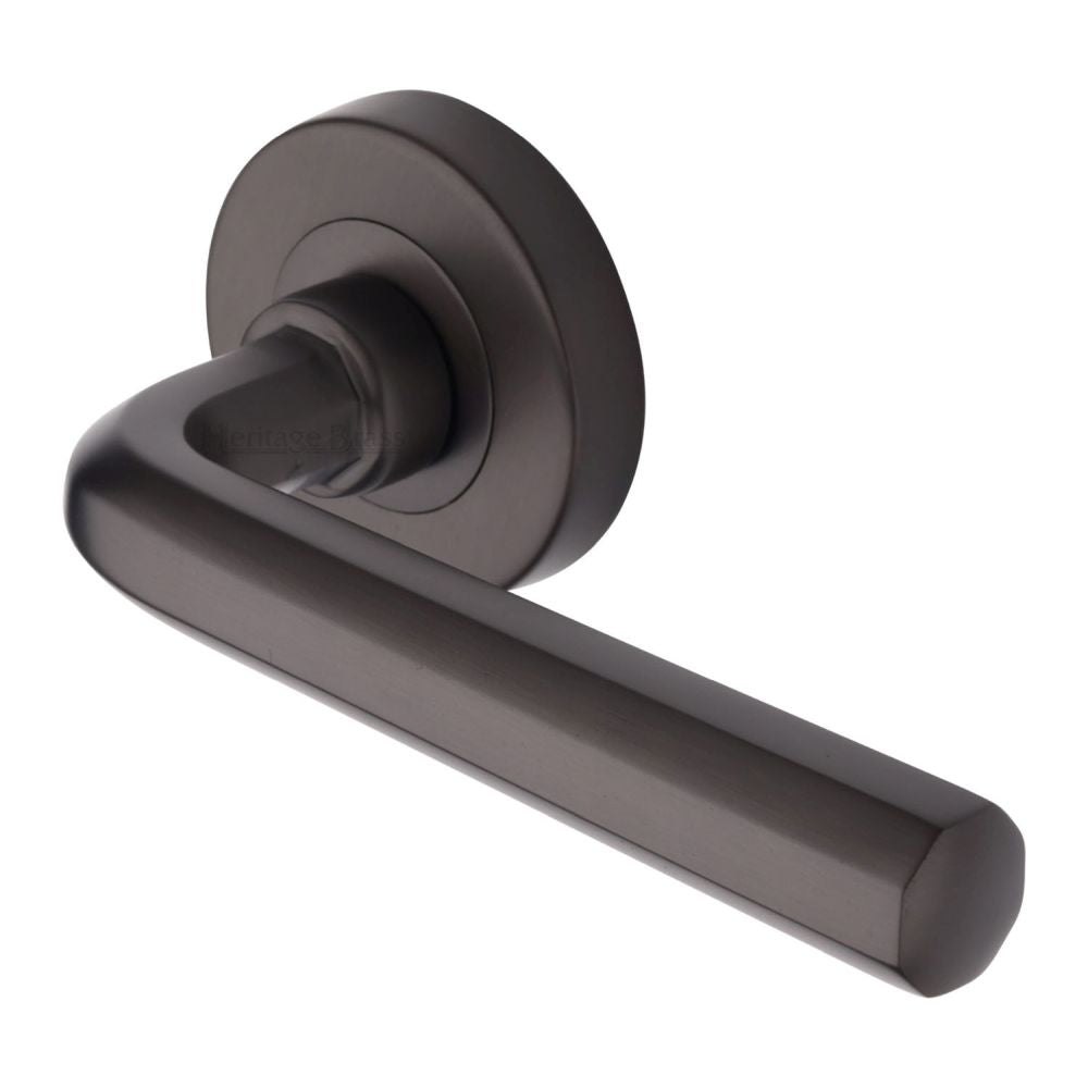 This is an image of a Heritage Brass - Door Handle Lever Latch on Round Rose Octave Design Matt Bronze, v4545-mb that is available to order from T.H Wiggans Ironmongery in Kendal.