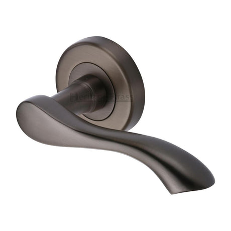 This is an image of a Heritage Brass - Door Handle Lever Latch on Round Rose Algarve Design Matt Bronz, v7210-mb that is available to order from T.H Wiggans Ironmongery in Kendal.