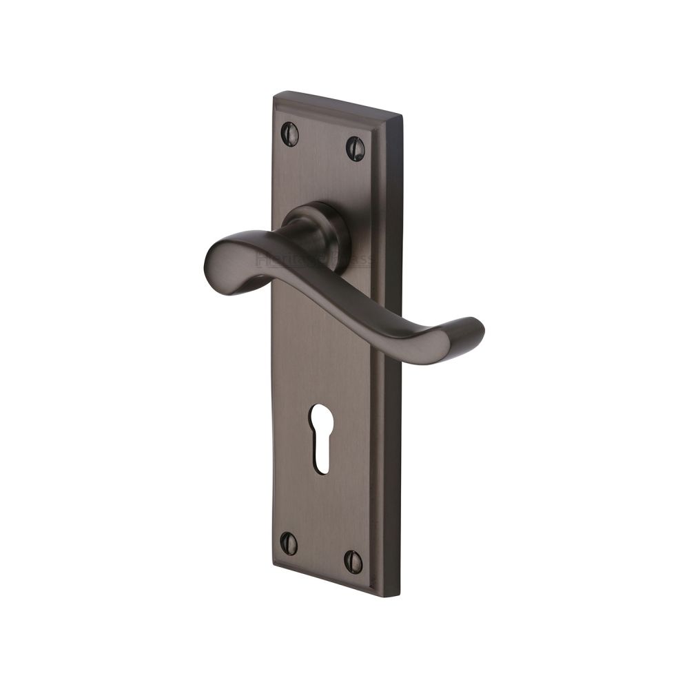This is an image of a Heritage Brass - Door Handle Lever Lock Edwardian Design Matt Bronze Finish, w3200-mb that is available to order from T.H Wiggans Ironmongery in Kendal.