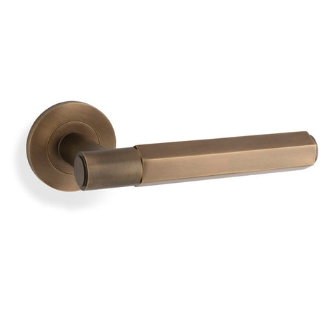 This is an image showing Alexander & Wilks - Spitfire Hex Lever on Round Rose - Italian Brass aw224ib available to order from T.H. Wiggans Ironmongery in Kendal, quick delivery and discounted prices.