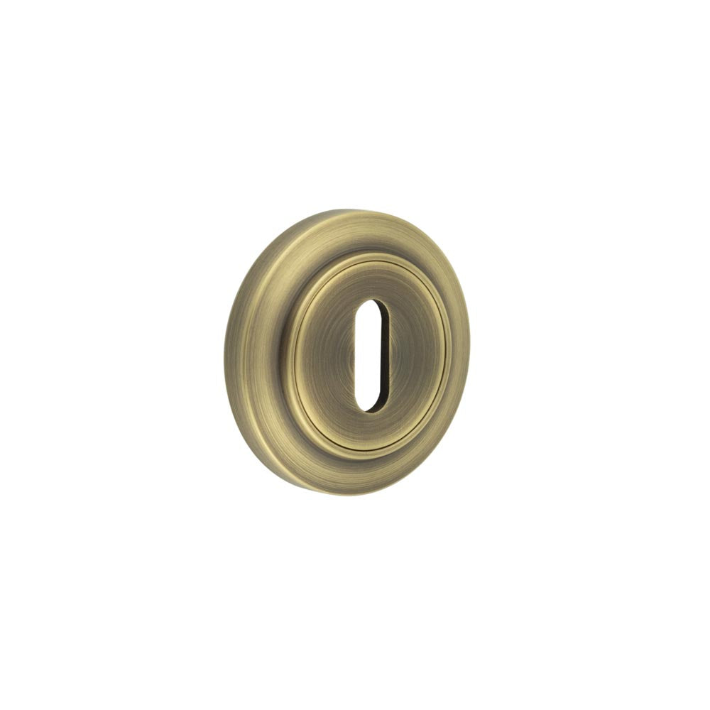 This is an image showing the Frelan - Burlington Standard Keyway Escutcheons Chamfered Rose Antique Brass available to order from T.H. Wiggans Ironmongery in Kendal
