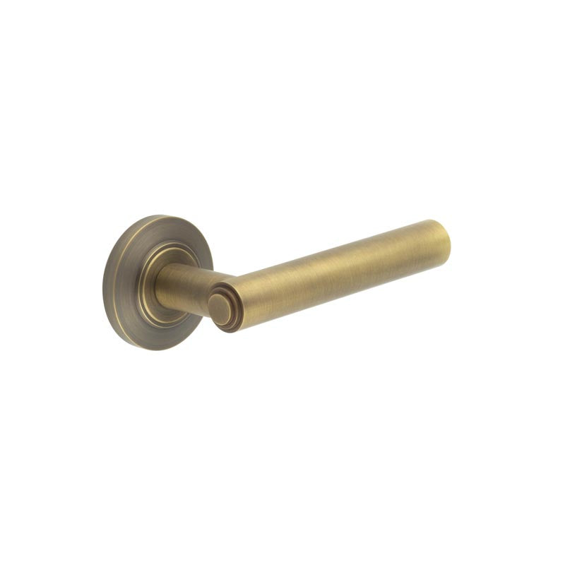 This is an image showing the Frelan - Richmond Door Handles Chamfered Rose Antique Brass available to order from T.H. Wiggans Ironmongery in Kendal