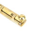 This is an image showing From The Anvil - Polished Brass 4" Universal Bolt available from trade door handles, quick delivery and discounted prices