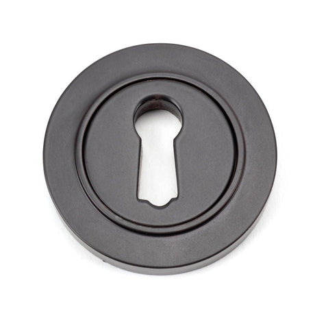This is an image of From The Anvil - Aged Bronze Round Escutcheon (Plain) available to order from T.H Wiggans Architectural Ironmongery in Kendal, quick delivery and discounted prices.