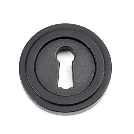 This is an image of From The Anvil - Matt Black Round Escutcheon (Art Deco) available to order from T.H Wiggans Architectural Ironmongery in Kendal, quick delivery and discounted prices.