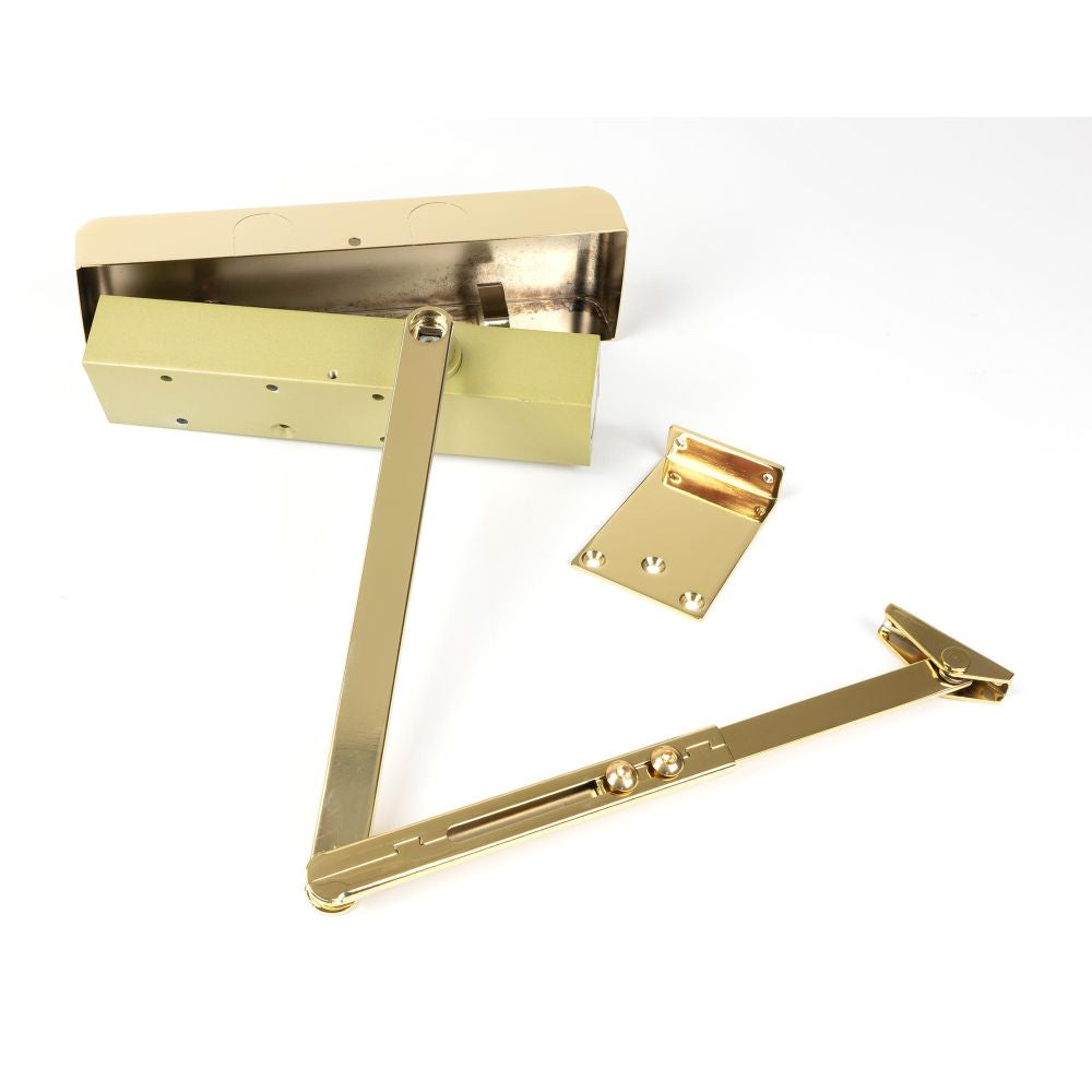 This is an image showing From The Anvil - Polished Brass Size 2-5 Door Closer & Cover available from trade door handles, quick delivery and discounted prices