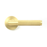 This is an image showing From The Anvil - Satin Brass Brompton Lever on Rose Set (Plain) available from trade door handles, quick delivery and discounted prices