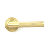 This is an image showing From The Anvil - Satin Brass Brompton Lever on Rose Set (Beehive) available from trade door handles, quick delivery and discounted prices
