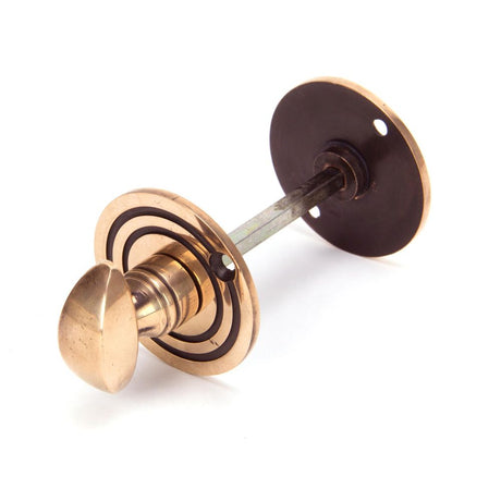 This is an image of From The Anvil - Polished Bronze Round Bathroom Thumbturn available to order from T.H Wiggans Architectural Ironmongery in Kendal, quick delivery and discounted prices.