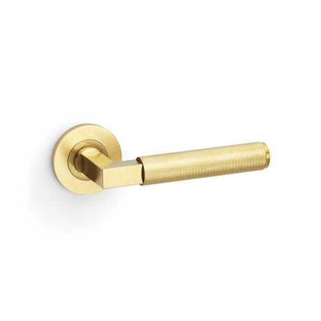This is an image showing Alexander & Wilks Hurricane Knurled Lever on Round Rose - Satin Brass PVD aw200sbpvd available to order from T.H Wiggans Ironmongery in Kendal, quick delivery and discounted prices.