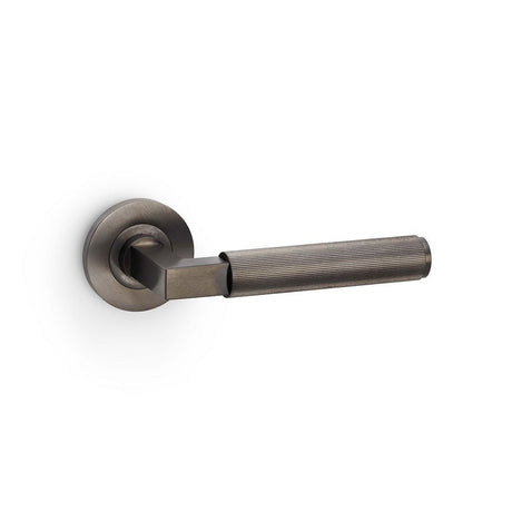 This is an image showing Alexander & Wilks Hurricane Reeded Lever on Round Rose - Dark Bronze PVD aw202dbzpvd available to order from T.H Wiggans Ironmongery in Kendal, quick delivery and discounted prices.