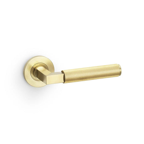This is an image showing Alexander & Wilks Hurricane Reeded Lever on Round Rose - Satin Brass PVD aw202sbpvd available to order from T.H Wiggans Ironmongery in Kendal, quick delivery and discounted prices.
