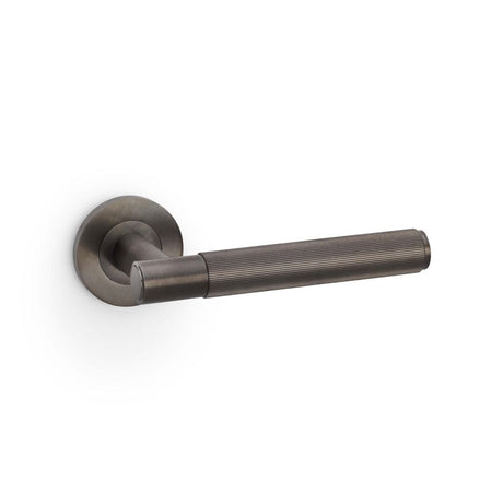 This is an image showing Alexander & Wilks Spitfire Reeded Lever on Round Rose - Dark Bronze PVD aw222dbzpvd available to order from T.H Wiggans Ironmongery in Kendal, quick delivery and discounted prices.