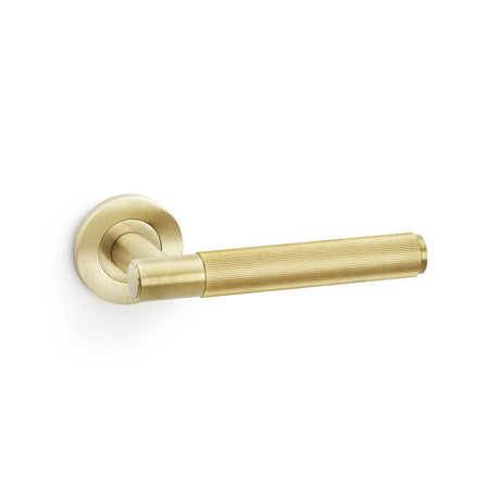 This is an image showing Alexander & Wilks Spitfire Reeded Lever on Round Rose - Satin Brass PVD aw222sbpvd available to order from T.H Wiggans Ironmongery in Kendal, quick delivery and discounted prices.