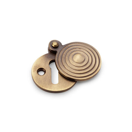 This is an image showing Alexander & Wilks Standard Key Profile Round Escutcheon with Christoph Design Cover - Antique Brass aw382-ab available to order from T.H Wiggans Ironmongery in Kendal, quick delivery and discounted prices.