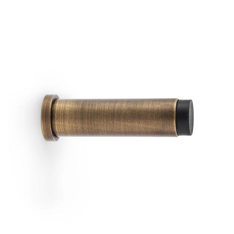 This is an image showing Alexander & Wilks Plain Projection Cylinder Door Stop - Antique Brass aw601-75-ab available to order from T.H Wiggans Ironmongery in Kendal, quick delivery and discounted prices.