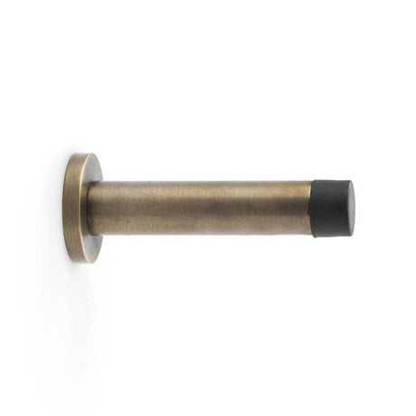 This is an image showing Alexander & Wilks Cylinder Projection Door Stop on Rose - Antique Brass aw616ab available to order from T.H Wiggans Ironmongery in Kendal, quick delivery and discounted prices.