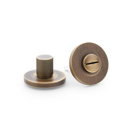 This is an image showing Alexander & Wilks Reeded Thumbturn and Release - Antique Brass aw792ab available to order from T.H Wiggans Ironmongery in Kendal, quick delivery and discounted prices.