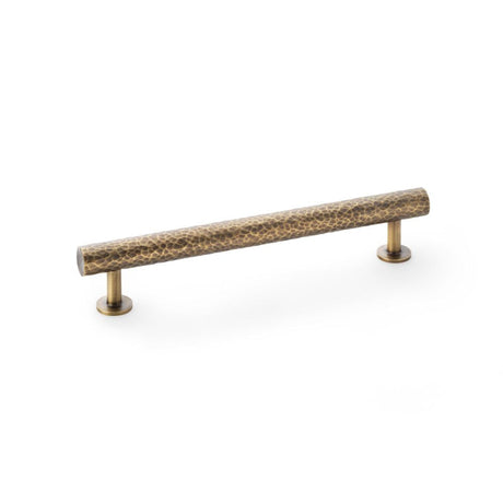 This is an image showing Alexander & Wilks Leila Hammered Cabinet Pull - Antique Brass aw817-160-ab available to order from T.H Wiggans Ironmongery in Kendal, quick delivery and discounted prices.