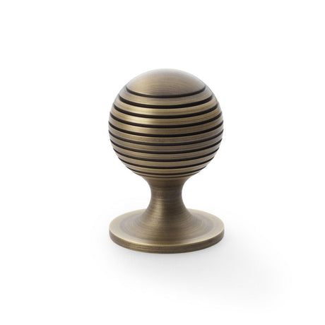 This is an image showing Alexander & Wilks Caesar Cupboard Knob on Round Rose - Antique Brass - 38mm aw832-38-ab available to order from T.H Wiggans Ironmongery in Kendal, quick delivery and discounted prices.