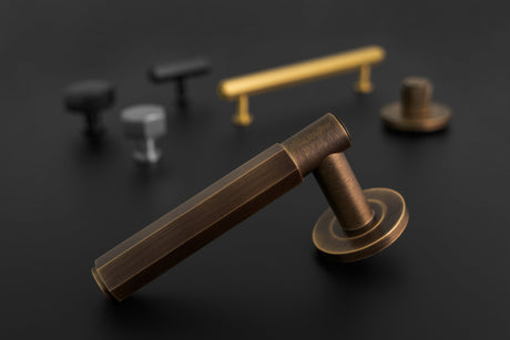 This is an image showing a door handle and cabinet hardware from the Alexander & Wilks Hexagon collection