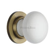 This is an image of a Heritage Brass - White Knob with Antique Brass base, 5010-at that is available to order from T.H Wiggans Ironmongery in Kendal.