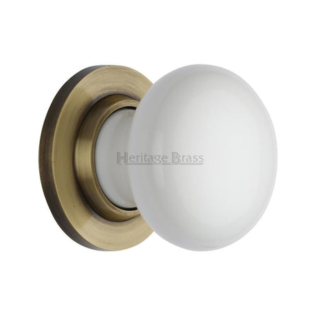 This is an image of a Heritage Brass - White Knob with Antique Brass base, 5010-at that is available to order from T.H Wiggans Ironmongery in Kendal.