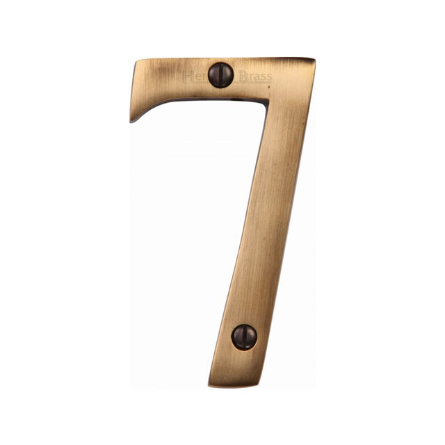 This is an image of a Heritage Brass - Numeral 7 Face Fix 76mm (3") Antique Brass Finish, c1560-7-at that is available to order from T.H Wiggans Ironmongery in Kendal.