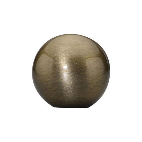 This is an image of a Heritage Brass - Cabinet Knob Globe Design 25mm Antique Brass Finish, c3627-at that is available to order from T.H Wiggans Ironmongery in Kendal.