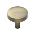 This is an image of a Heritage Brass - Cabinet Knob Domed Disc Design 32mm Antique Brass Finish, c3875-32-at that is available to order from T.H Wiggans Ironmongery in Kendal.